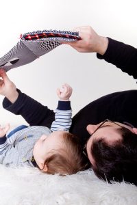 new Dad reading a book to a Baby