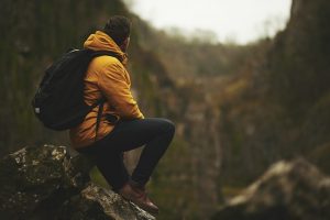 Man sitting on rocks, backpack