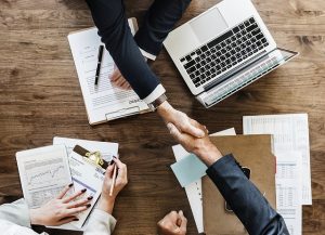 business men shaking hands over table