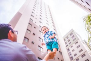 Dad holding a Baby up outside