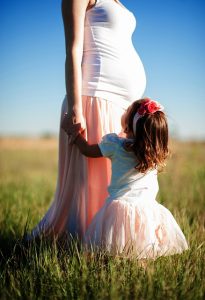 toddler clinging to pregnant Mom