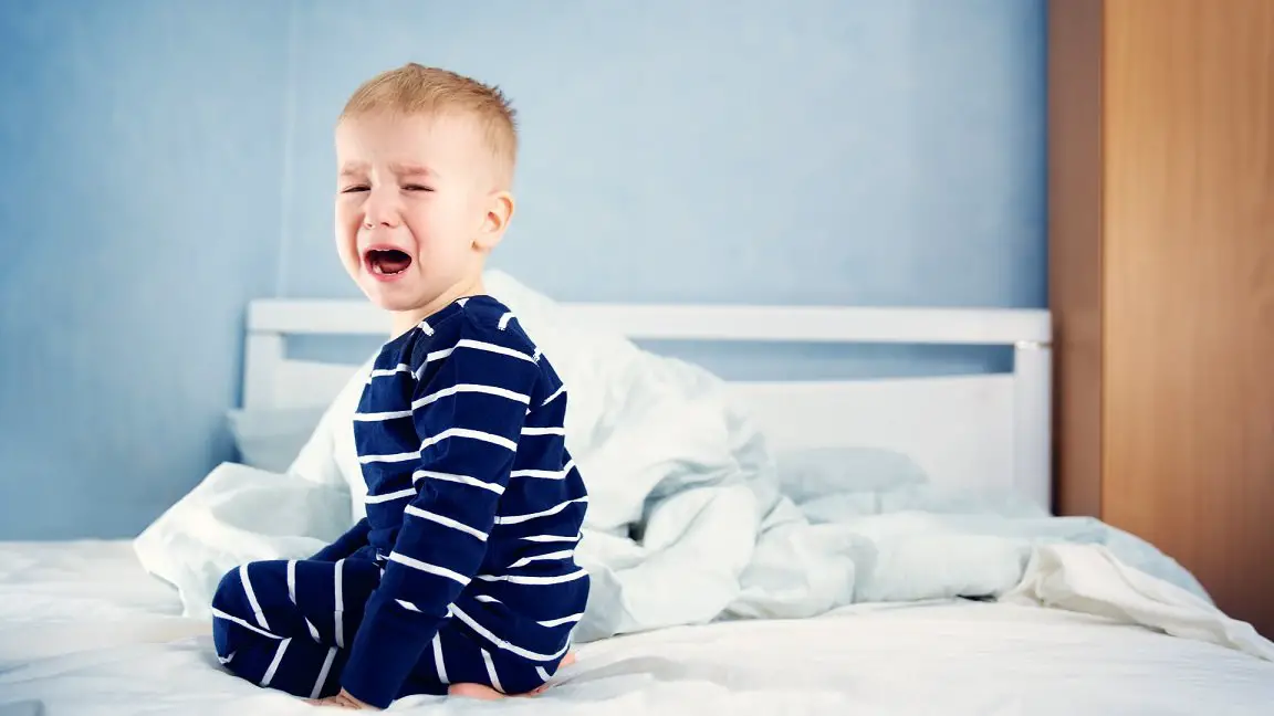 toddler crying in a bed