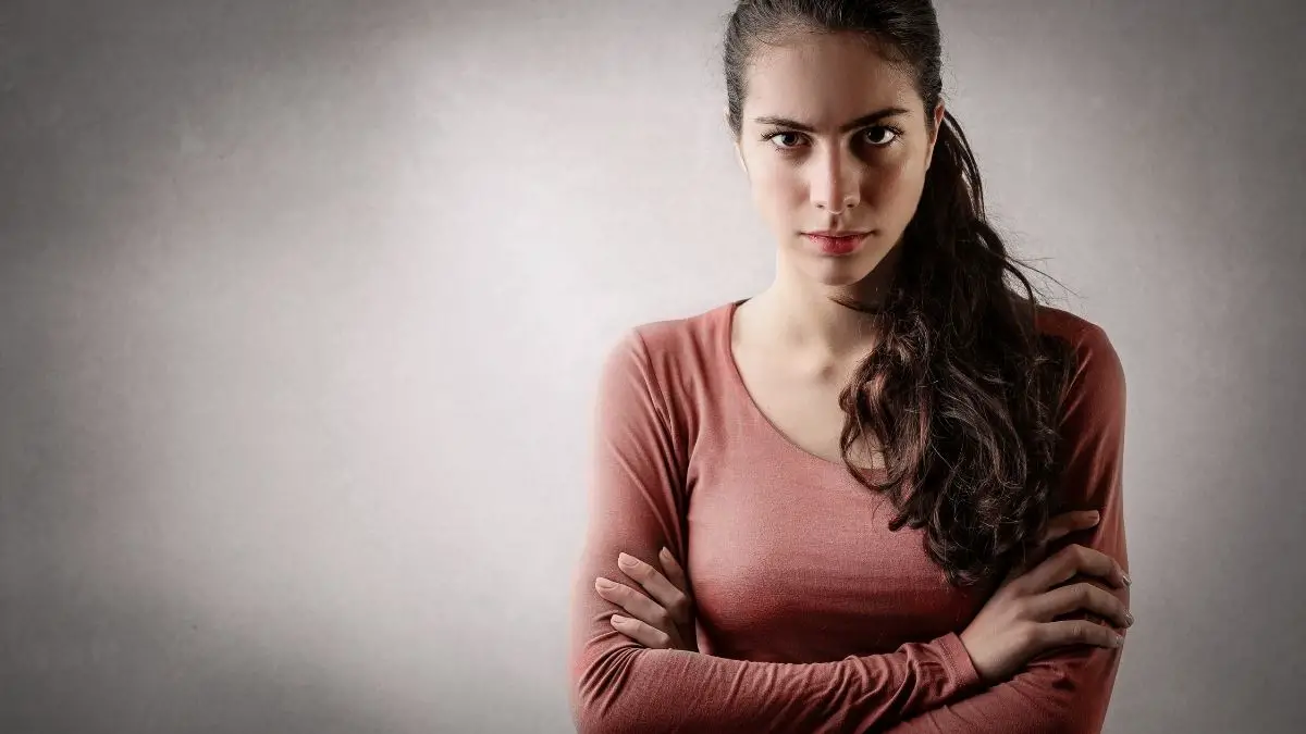 annoyed woman staring at camera with arms crossed