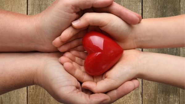 parent and child hands with love heart inside