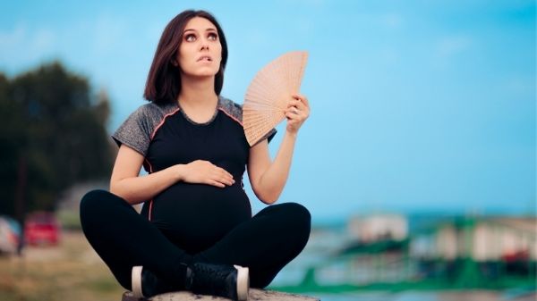 pregnant lady fanning herself hot flash