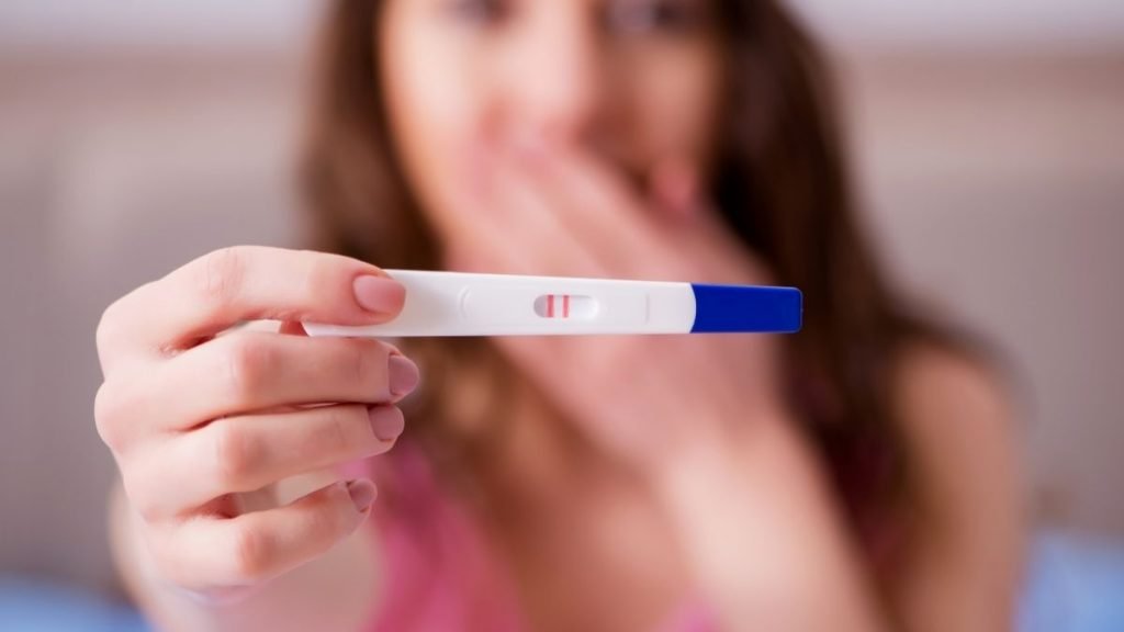pregnant lady showing positive pregnancy test
