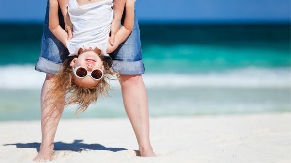 fun girl hanging upside down on beach