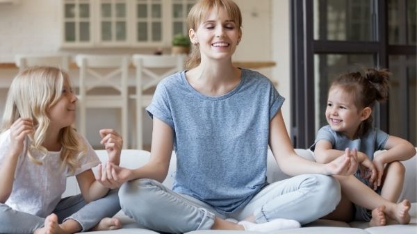 mom meditating to relax with 2 kids