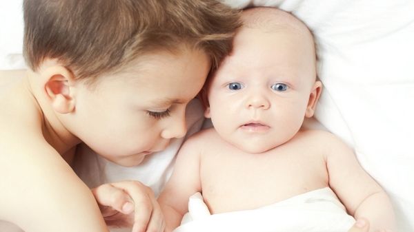 baby laying with older brother bonding