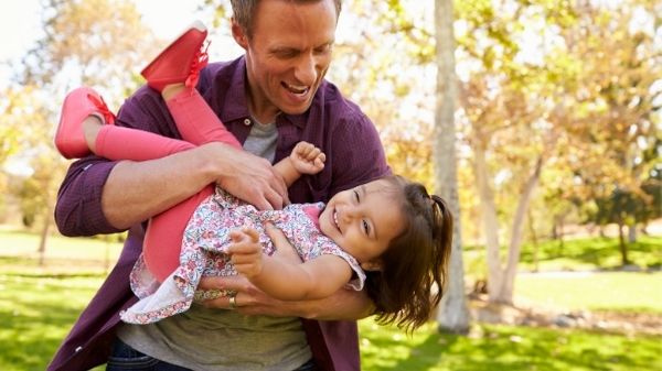 dad playing with toddler daughter tickling