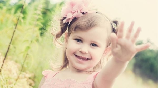 happy 3 year old giving high five to camera