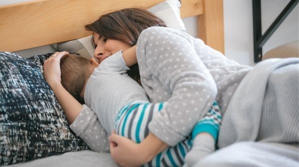 toddler hugging mommy in bed