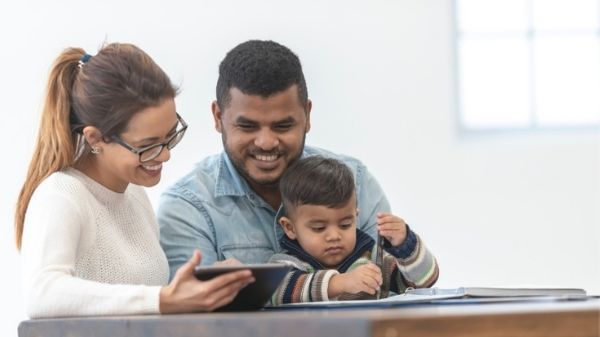 mom reading to toddler on dads lap