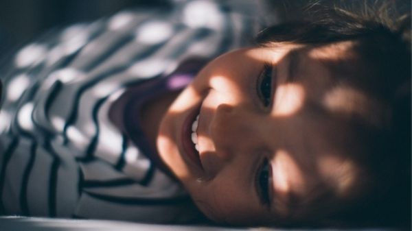 toddler laying in bed