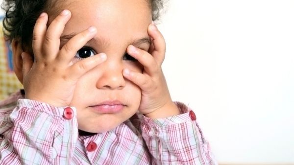 toddler with head in hands