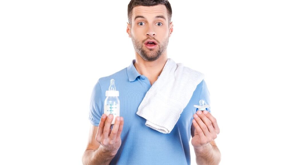 dad with bottle and pacifier looking worried