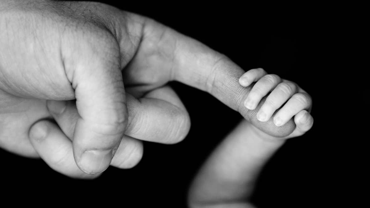 newborn gripping dads finger