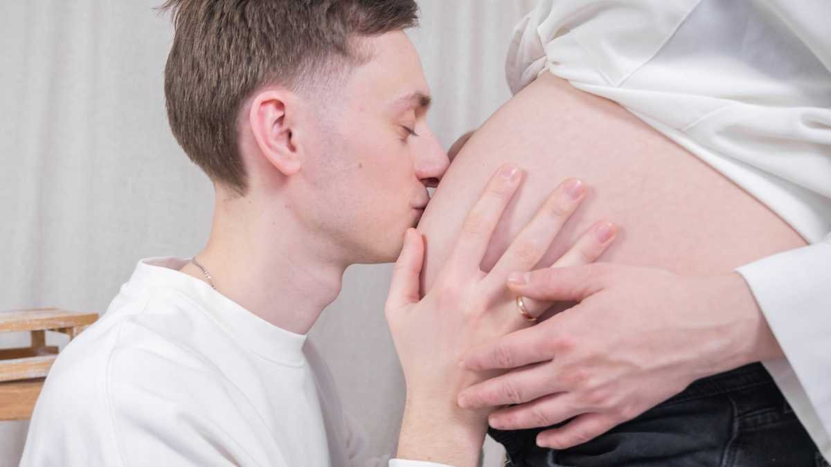 young dad kissing pregnant belly