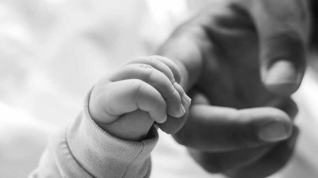 baby holding dads finger bonding