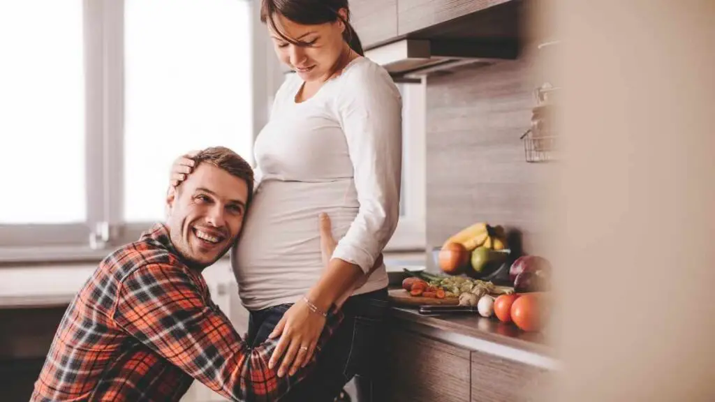 dad hugging pregnant bump