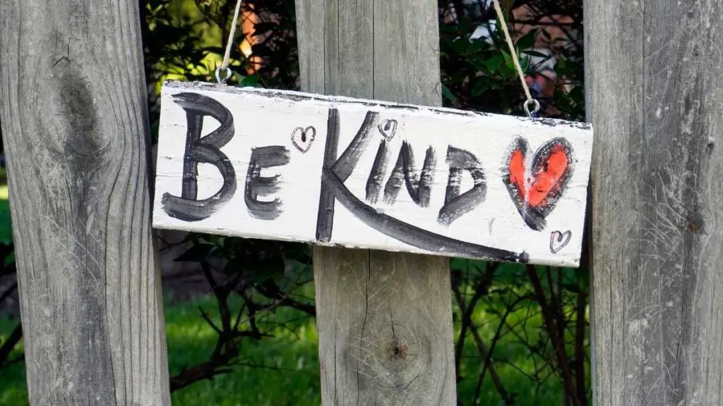 garden sign says be kind with red heart