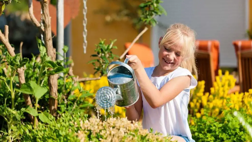 girl helping by watering plants