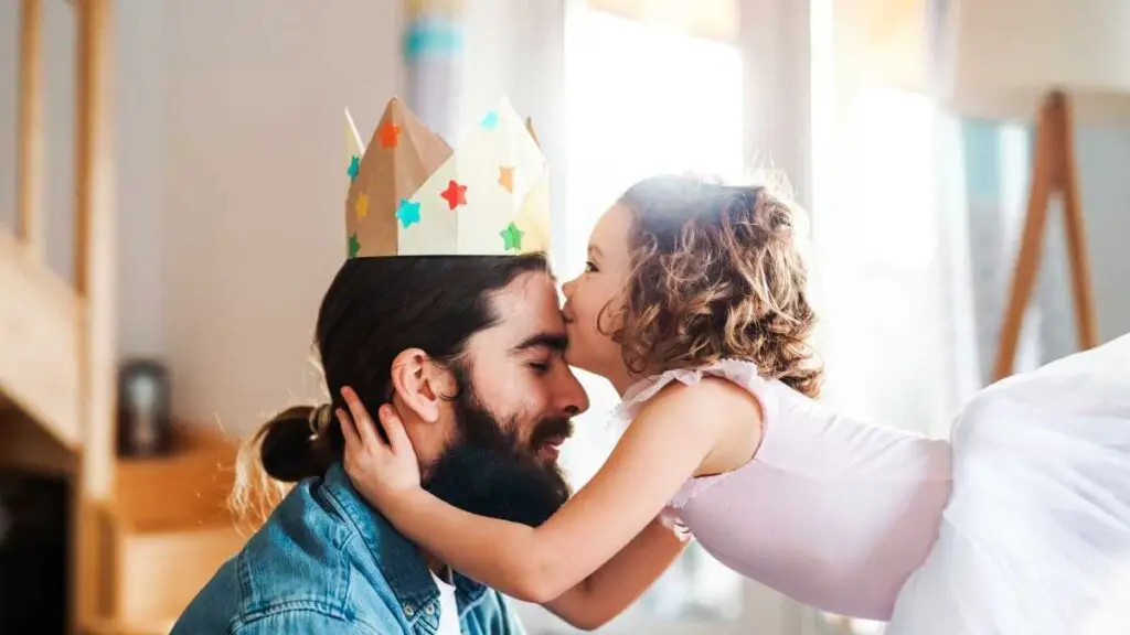 man being kissed by his daughter dressed as a princess