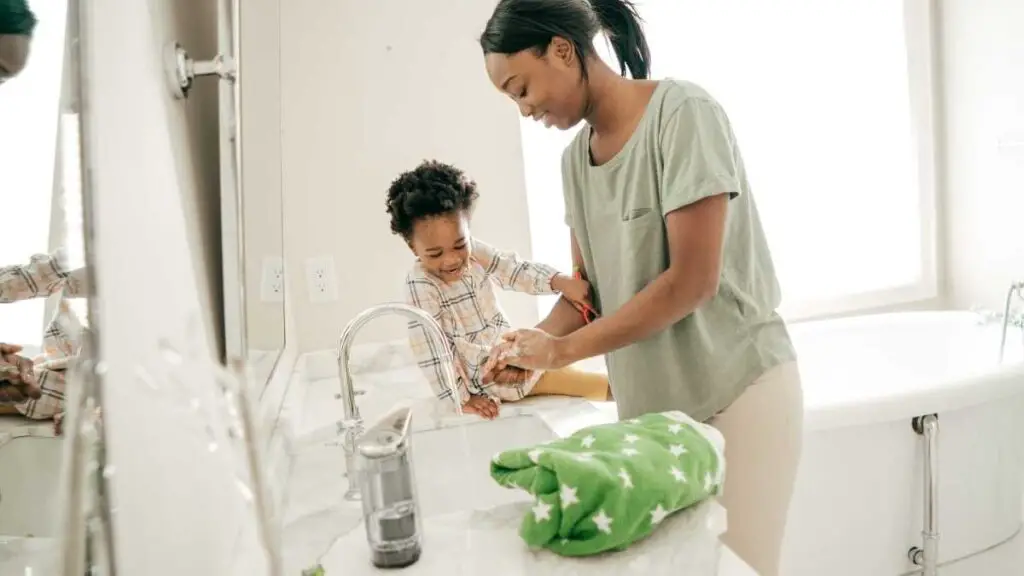 mom washing hands with toddler