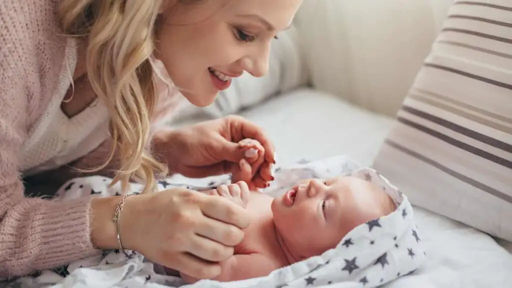 new mom playing with newborn