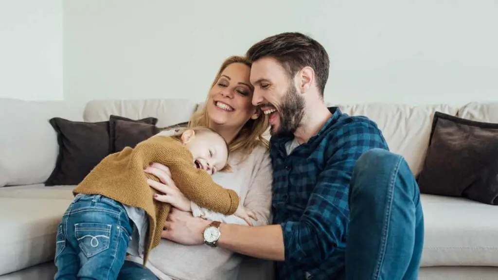 toddler hugging mom and dad on sofa