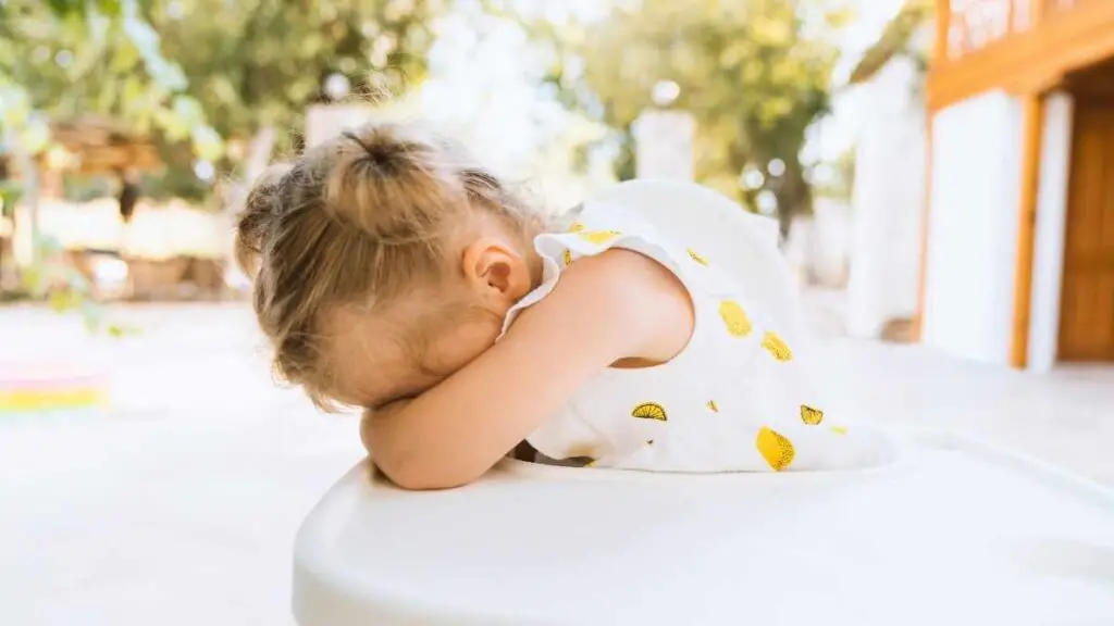 girl toddler sad in highchair