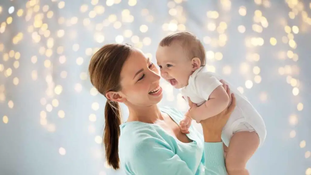 mom holding her baby in the air laughing