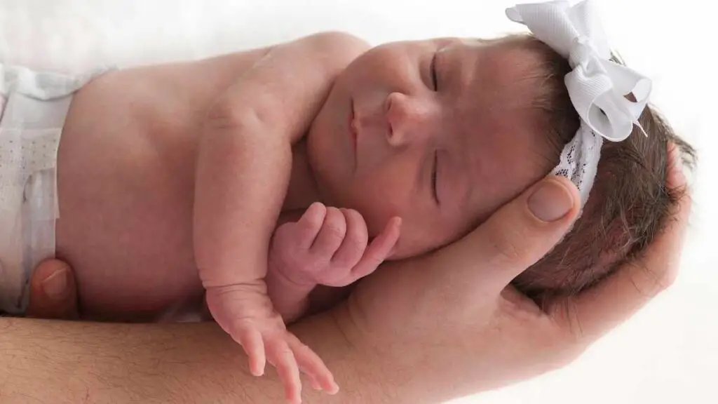 baby asleep on husbands arm