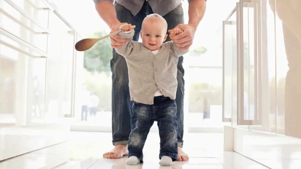 baby walking holding hands