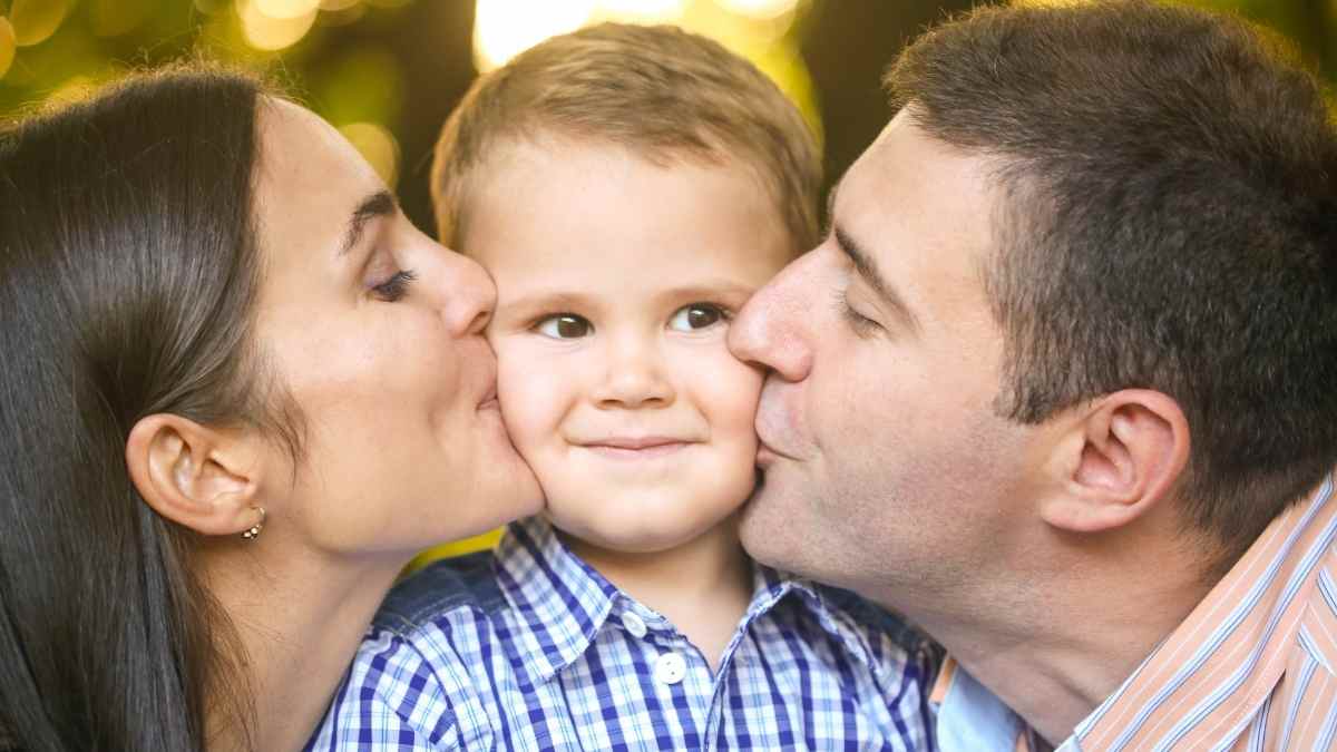 mom and dad kissing each cheek of their toddler son