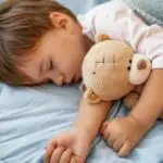 toddler fallen asleep with teddy