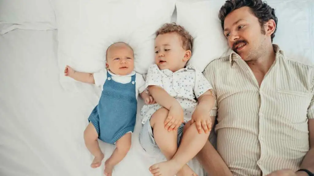 toddler in bed with sibling and dad