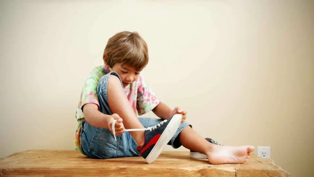 child tying shoe laces