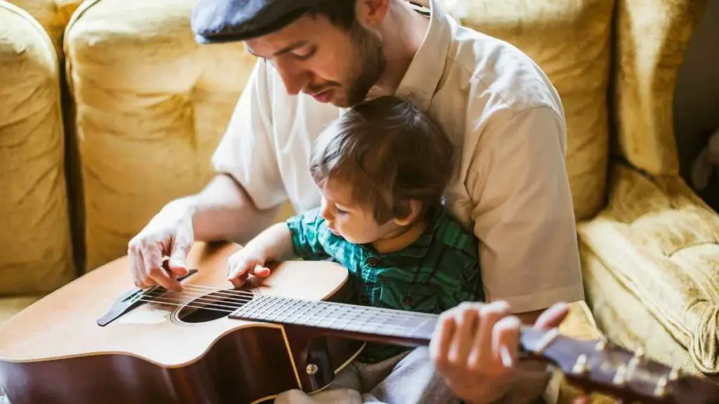 dad playing guitar with toddler distraction