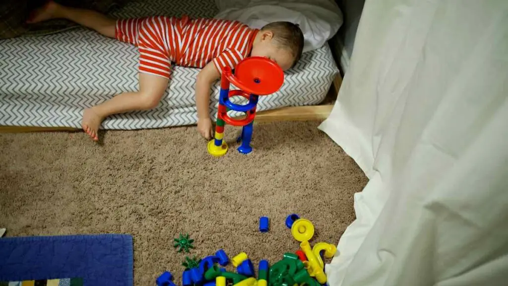 toddler playing with toy in bed